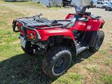 an image of a red four wheeler atv parked in the grass