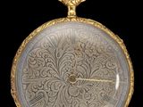 une vieille montre de poche en or avec une chaîne, sur fond noir