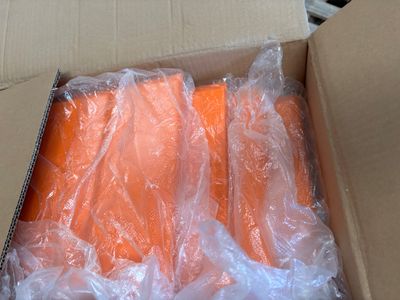 a box of carrots wrapped in plastic and sitting on a table
