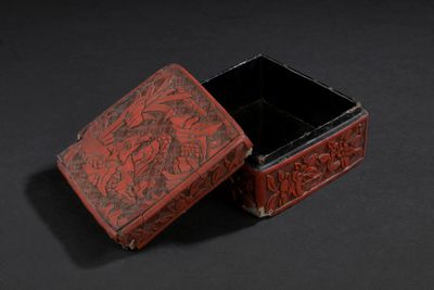 une vieille boîte rouge posée sur une surface noire