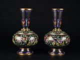une paire de vases posés sur une surface noire, sur fond noir