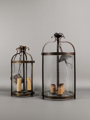 deux lanternes en verre contenant des bougies, posées sur une table
