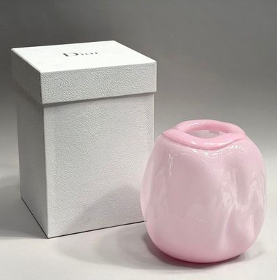a small pink vase sitting next to a white box