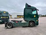two green trucks parked next to each other in a parking lot