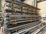 a large pile of steel bars stacked up in a warehouse
