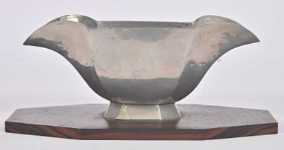 a silver vase sitting on top of a wooden stand