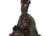 an image of a statue of a man sitting on a white surface