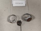 deux bagues et une paire de boucles d'oreilles posées sur une table