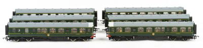 two green train cars sitting side by side on a white surface