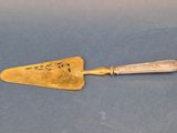 une spatule ancienne plaquée or sur un fond bleu