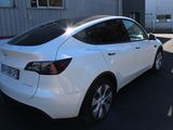 a white tesla car parked in a parking lot