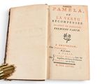 an open book with a gold hand resting on top of it