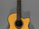 un gros plan d'une guitare acoustique sur fond gris
