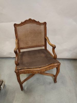 une vieille chaise en bois avec une assise marron et un dossier en rotin