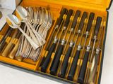 many forks and spoons in a case on the table