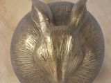 a gold sculpture of a mouse on a purple shelf