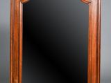 an antique wooden mirror with a carved frame