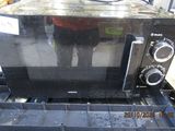 a black microwave sitting on top of a blue box