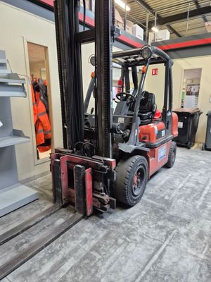 a red forklift truck parked in a warehouse