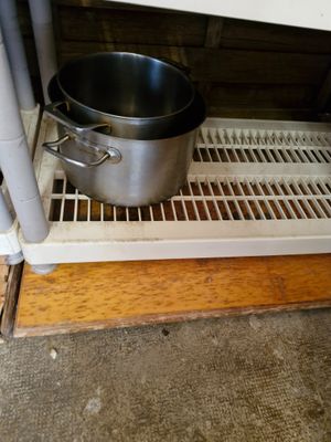 une casserole et une poêle posées sur une étagère dans une cuisine