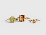 a set of three rings and a ring with a green stone