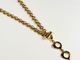 a close up of a gold necklace with a chain attached to it
