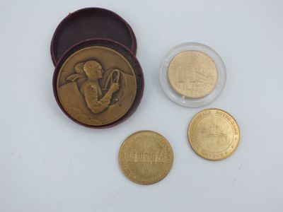 deux pièces d'or et un petit récipient en verre sur lequel figure l'image d'un homme