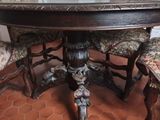 a table with four chairs and a vase on top of it