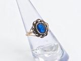 an image of a close up of a ring with a blue stone