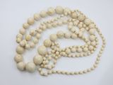 a close up of a white beaded necklace on a white surface