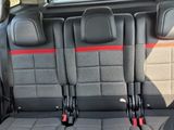 three seats in the back of a car that are black and red