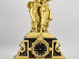 une image représentant une horloge surmontée d'une statue
