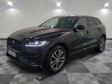 un SUV Jaguar noir garé sur un sol à damier dans un garage
