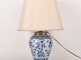 une lampe bleue et blanche avec un abat-jour beige