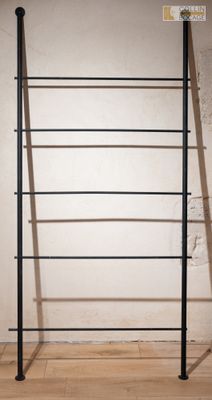 une photo montrant un portant de vêtements posé sur un plancher en bois