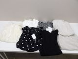 une table blanche recouverte d'une multitude de vêtements