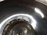 a metal bowl with a hole in the middle of it