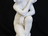 white marble statue of a boy sitting on a marble base