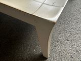 a white coffee table with a white top on a carpeted floor