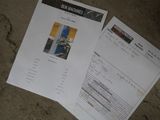 two papers on the ground with a picture of a building in the background