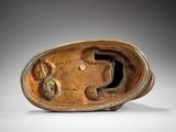 bronze sculpture of a dog in a bowl on a white surface
