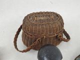 a wicker basket with a stone on the ground