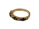 une image représentant une bague en or sertie de pierres noires et blanches
