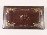 an old wooden box with a monogram on the front