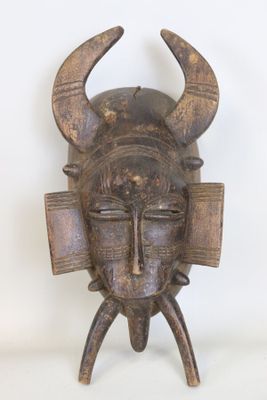 une image représentant un masque en bois orné de cornes sur la tête