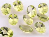 a close up of a bunch of green gems on a white surface