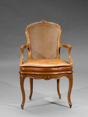 une chaise en bois avec une assise en cuir et un dossier en rotin