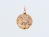 un pendentif en or avec la photo de deux femmes et d'un homme