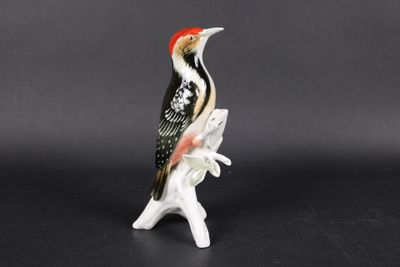 un gros plan d'une figurine représentant un oiseau perché sur une branche