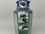 un vase vert et blanc orné d'un oiseau